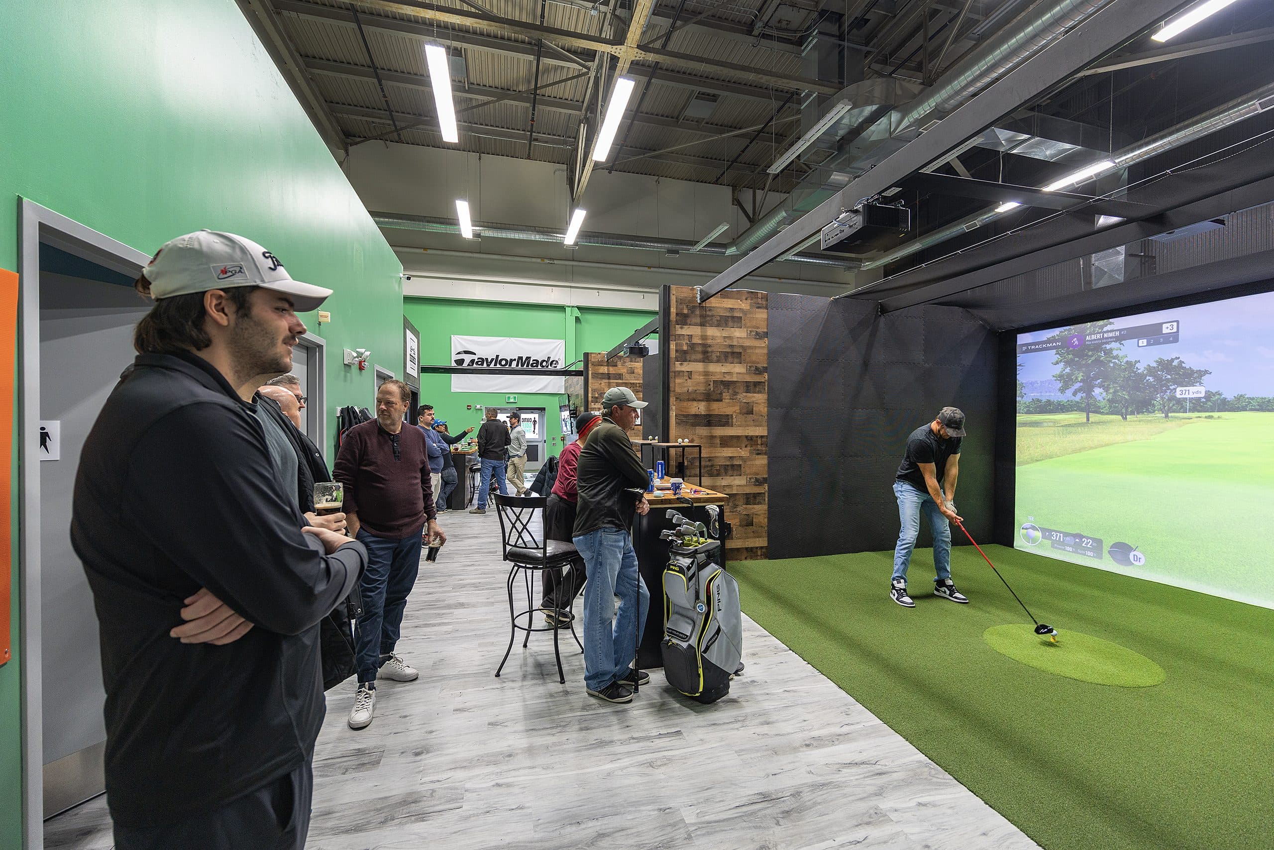 Friends playing simulator golf in Kingston